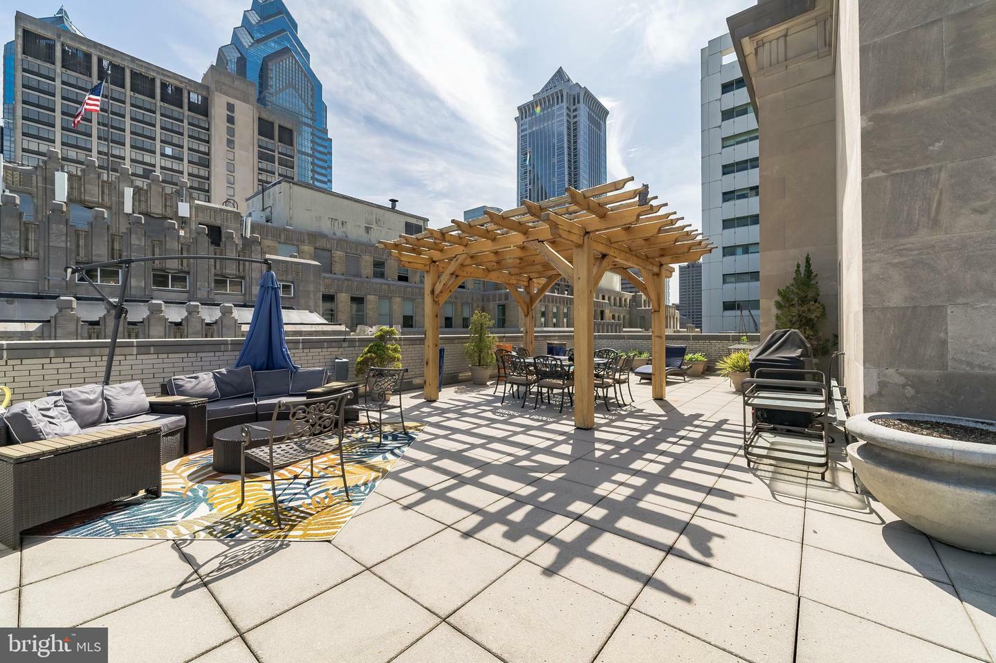 Simplistic and beautiful rooftop setting in Philadelphia with comfortable chairs and a panoramic city view.